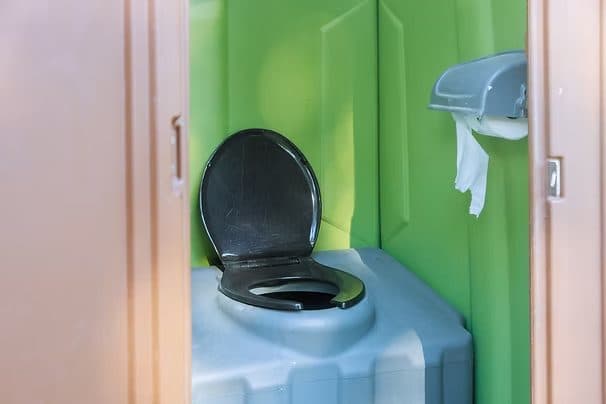 Clean portable restroom interior with seat and toilet paper holder